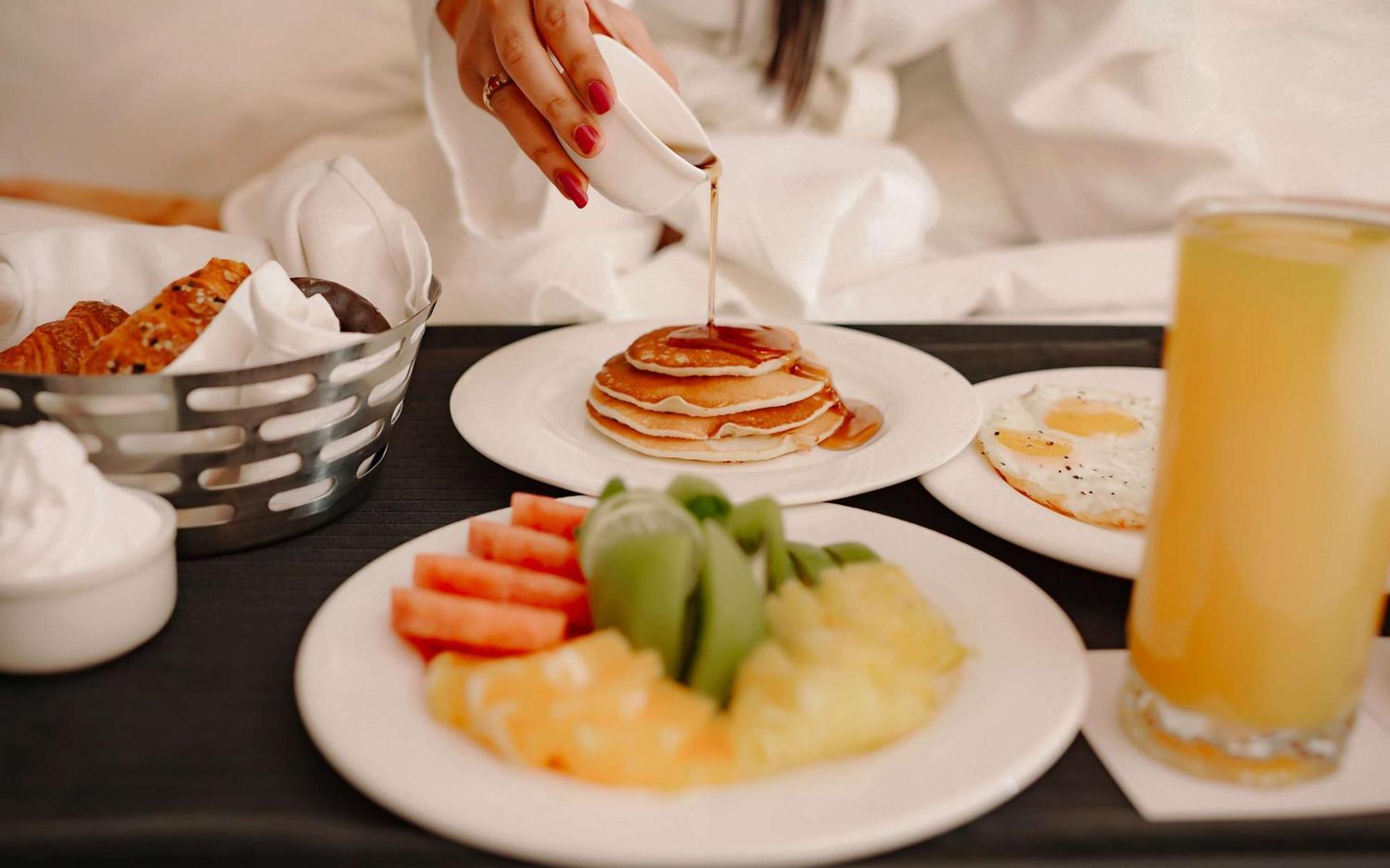 Radisson Blu Hotel Amritsar Extérieur photo A woman pouring maple syrup on a stack of pancakes